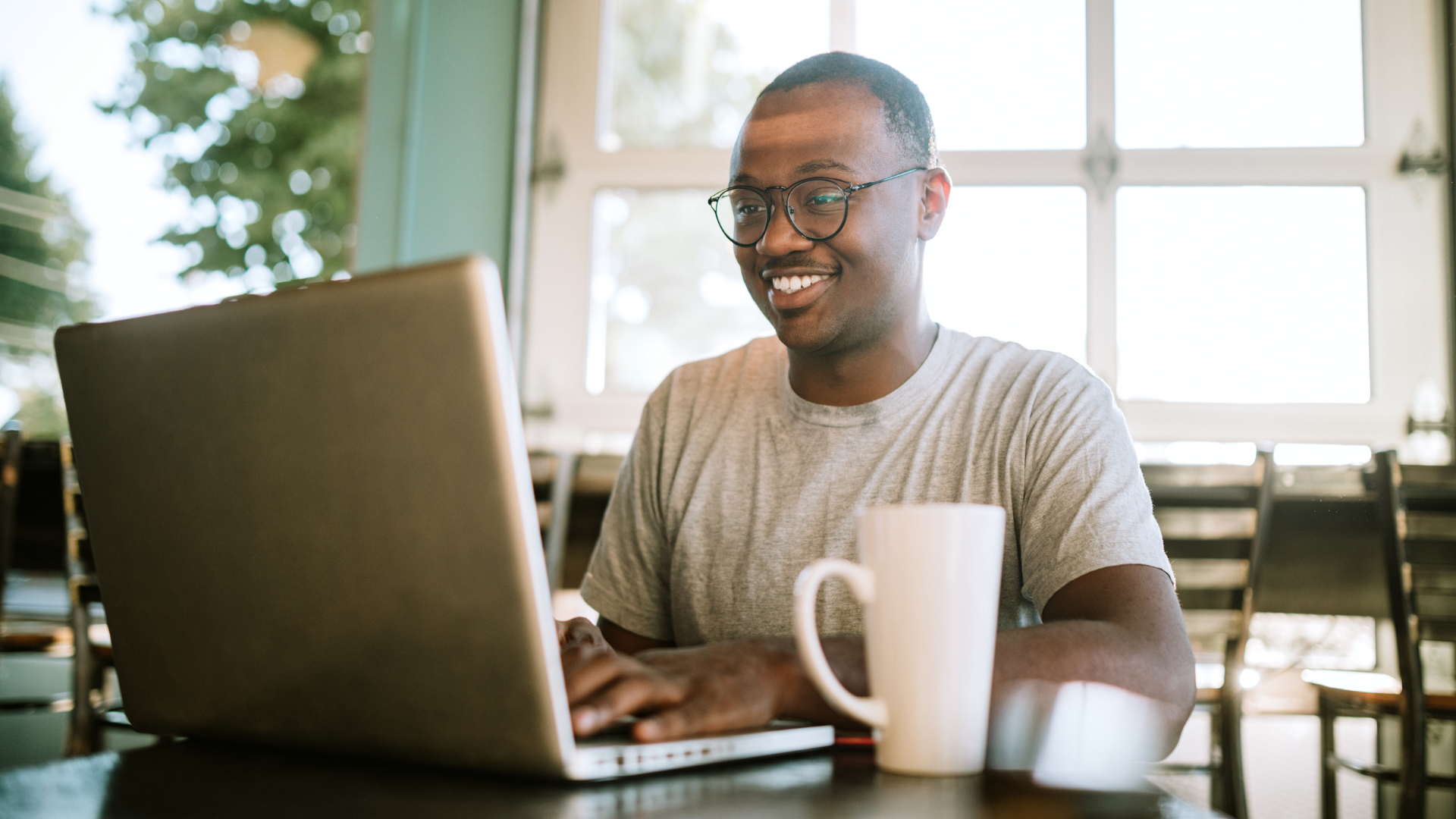 Smiling person using a laptop to represent audience intelligence and enrichment