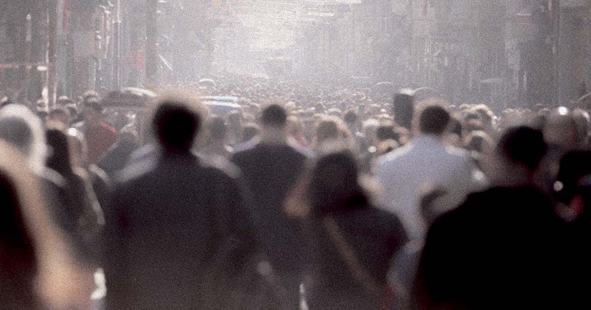 An extremely busy street of people walking from behind