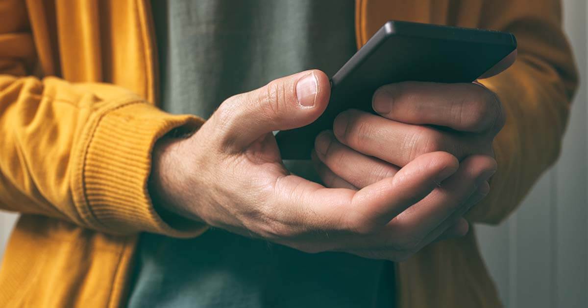 A close up photo of a person holding a mobile phone device in their hands